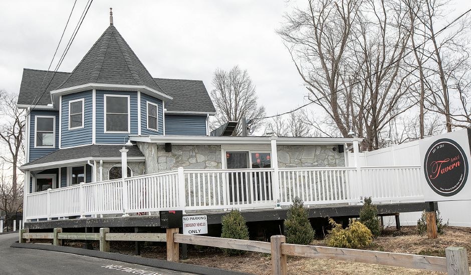 The blue Victorian building with a white deck that houses Amici Tavern at 43 Broadway in North Haven