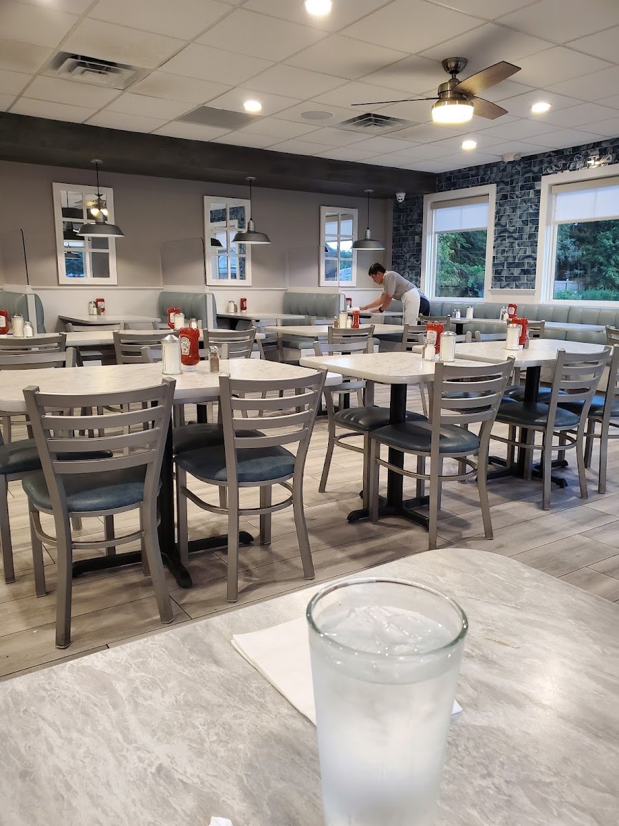 Tables and booths in the bright dining room at the Athena II Diner