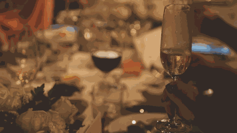 Friends raising a champagne toast at a candlelit dinner table