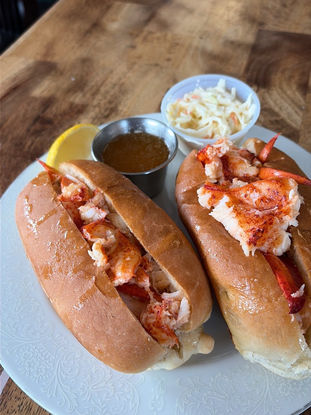 Two hot buttered lobster rolls with drawn butter, lemon and coleslaw at CT Chowder Co. in North Haven