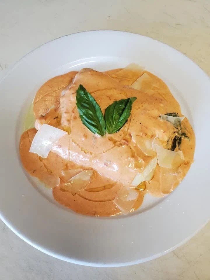 Lobster ravioli in pink cream sauce with basil and shaved cheese at Grand Apizza North