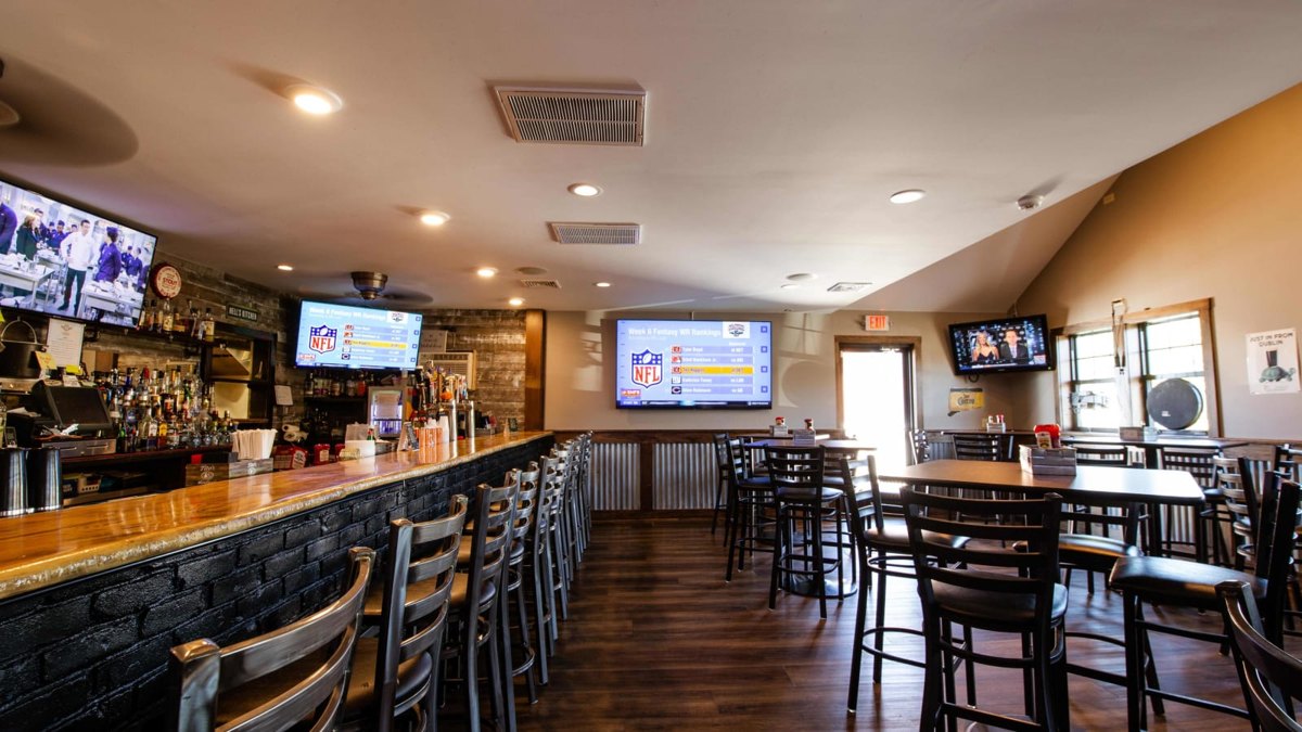 The long bar, high-top tables and wall of TVs in the dining room at the Hard Hat Cafe on Old Broadway East in North Haven