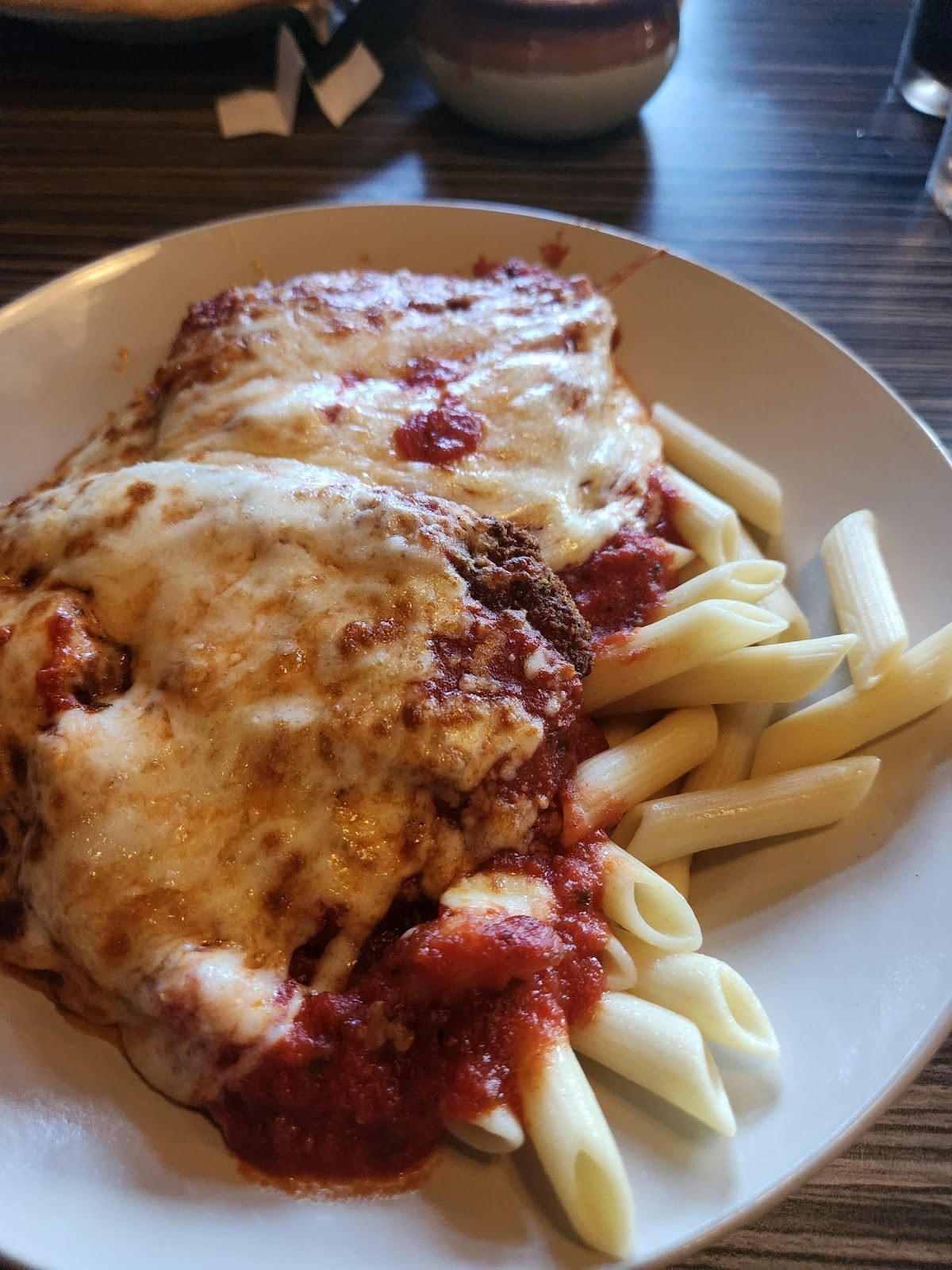 Chicken Parmesan with melted mozzarella and red sauce next to penne at J Roo’s