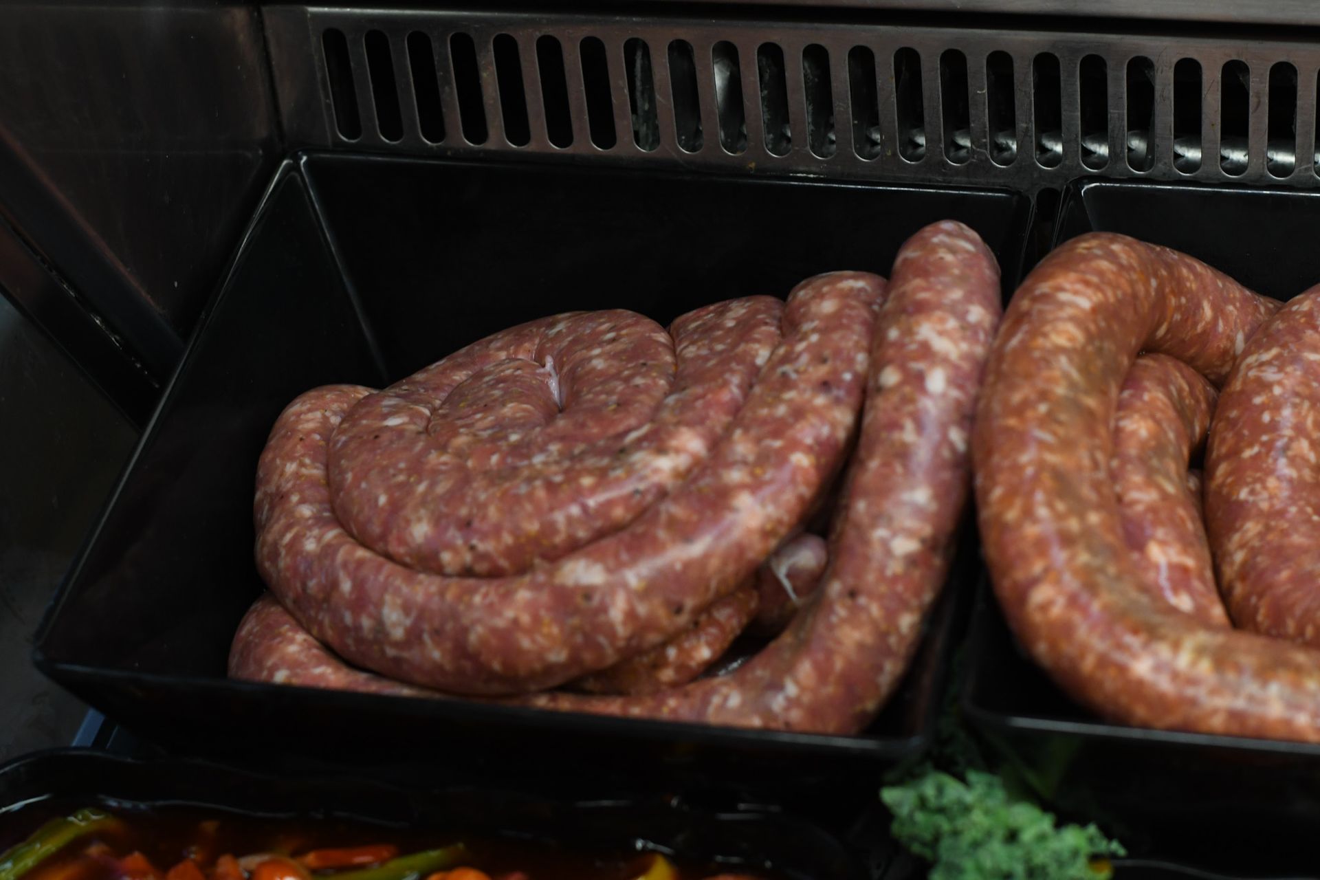 Coils of house-made sausage in the meat case at Liuzzi Gourmet Food Market