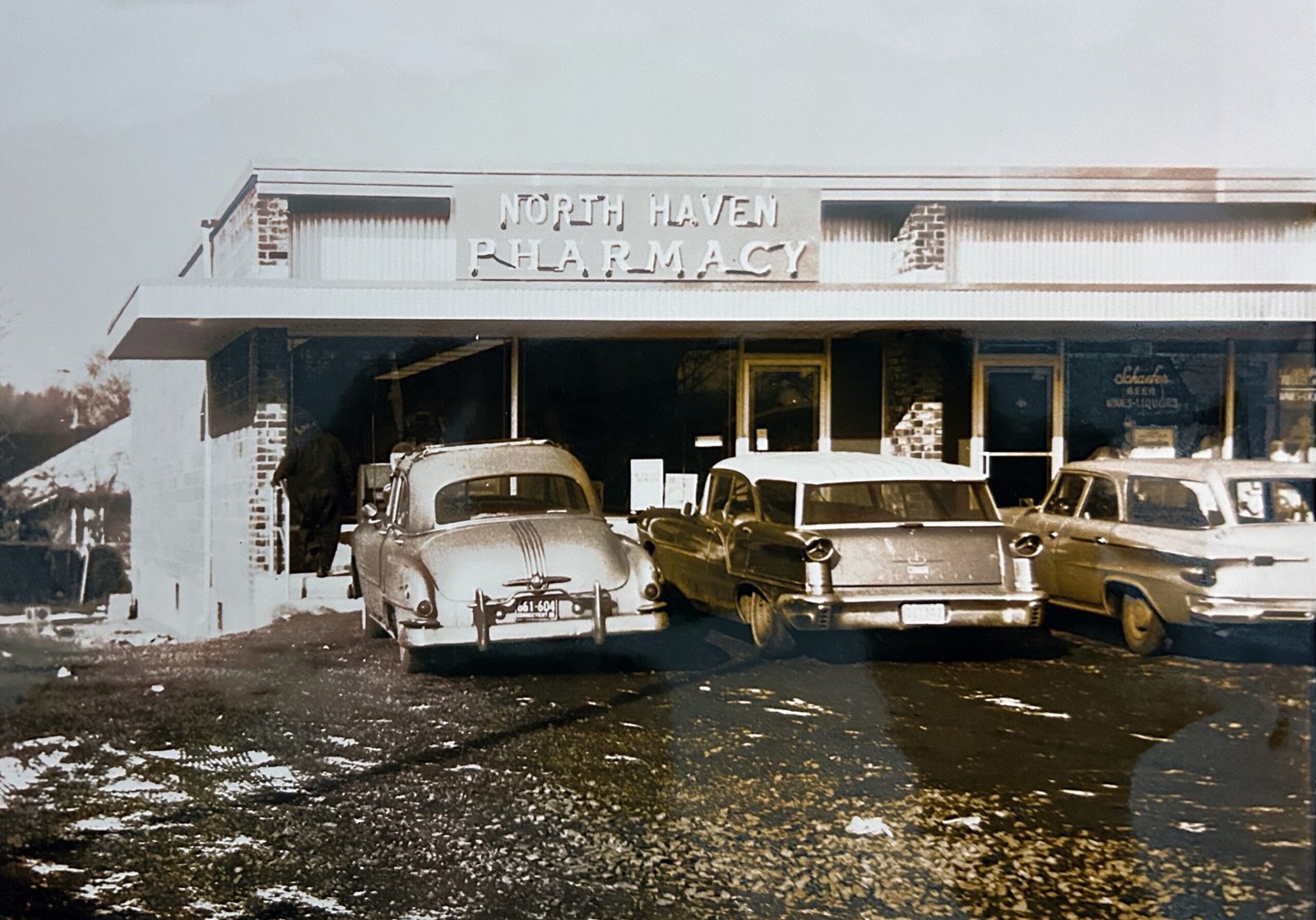 An early photo of North Haven Pharmacy, with cars of the era parked out front