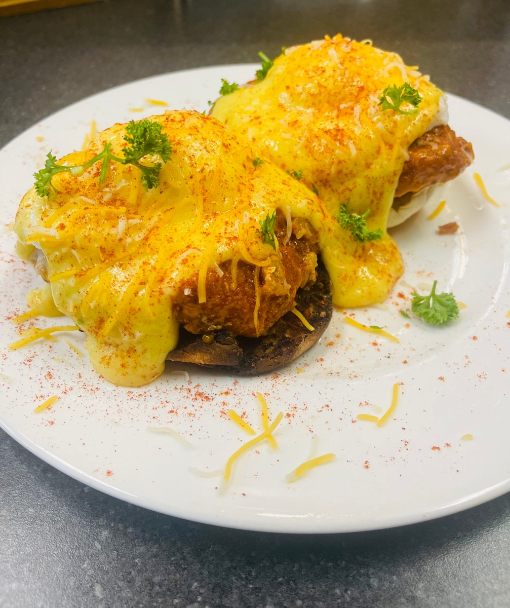 Classic eggs Benedict with hollandaise and shredded cheese at Sam's Place