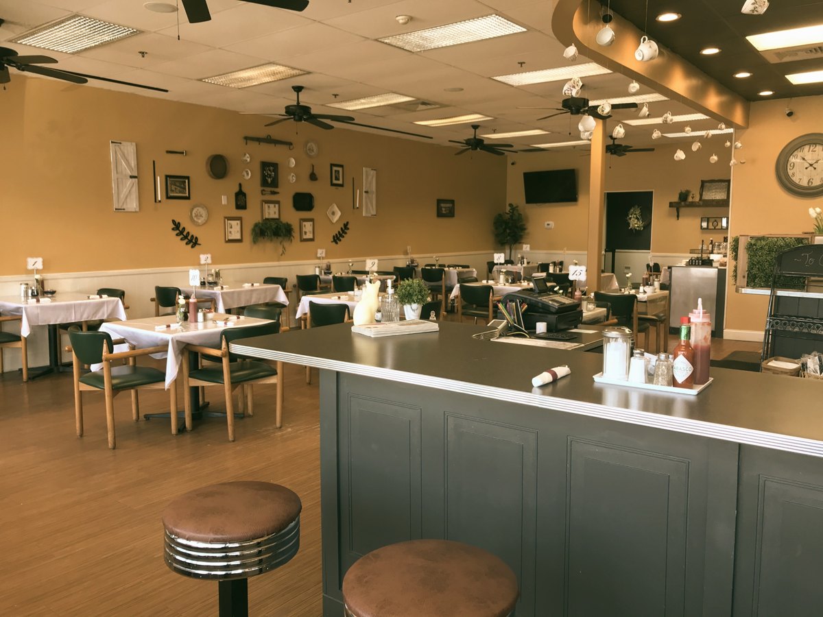 The dining room at Sam's Place on Washington Avenue in North Haven, with counter stools, framed pictures and white tablecloths